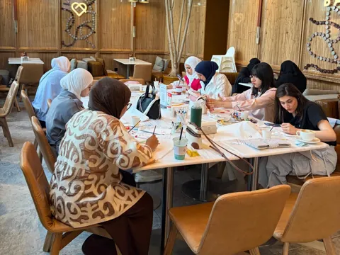 Large group painting together at a café community event