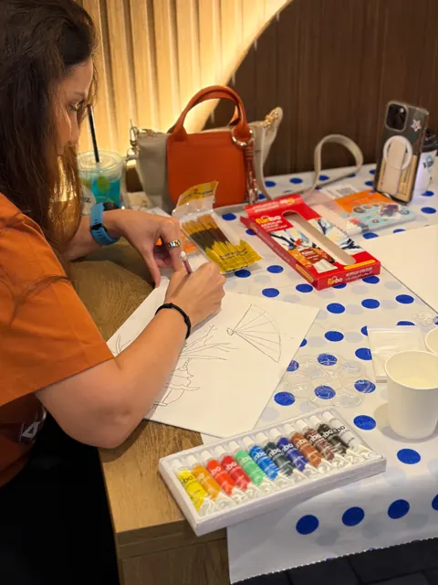 Guest sketching with a set of acrylic paints on the table